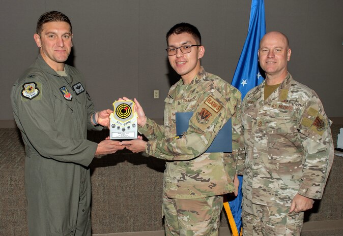 U.S. Air Force Col. Ethan E. Sabin, left, 57th Wing deputy commander, and Chief Master Sgt. Jason K. Trickey, right, 57th Wing command chief, present Senior Airman John Lee, a Radar, Airfield and Weather Systems technician assigned to the 57th Operational Support Squadron, with the Airman of the Quarter award at Nellis Air Force Base, Nevada, Nov. 20, 2024.