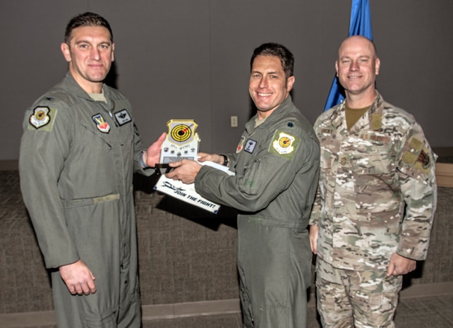 U.S. Air Force Col. Ethan E. Sabin, left, 57th Wing deputy commander, and Chief Master Sgt. Jason K. Trickey, right, 57th Wing command chief, present Lt. Col. Evan Roth, director of operations assigned to the 549th Combat Training Squadron, with the Field Grade Officer of the Quarter award at Nellis Air Force Base, Nevada, Nov. 20, 2024.