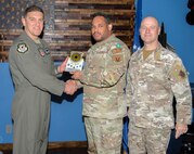 U.S. Air Force Col. Ethan Sabin, left, 57th Wing deputy commander, and Chief Master Sgt. Jason K. Trickey, right, 57th Wing command chief, present Tech. Sgt. Michael Tombaski, a loading standardization crew chief assigned to the 57th Maintenance Group, with the Noncommissioned Officer of the Quarter award at Nellis Air Force Base, Nevada, Nov. 20, 2024.