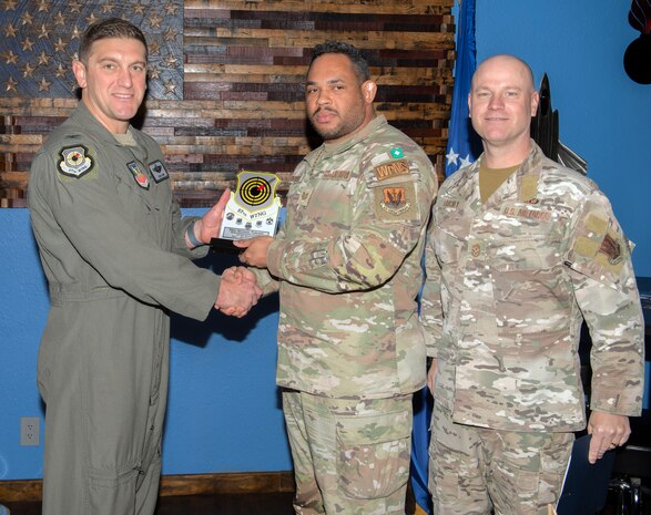 U.S. Air Force Col. Ethan Sabin, left, 57th Wing deputy commander, and Chief Master Sgt. Jason K. Trickey, right, 57th Wing command chief, present Tech. Sgt. Michael Tombaski, a loading standardization crew chief assigned to the 57th Maintenance Group, with the Noncommissioned Officer of the Quarter award at Nellis Air Force Base, Nevada, Nov. 20, 2024.