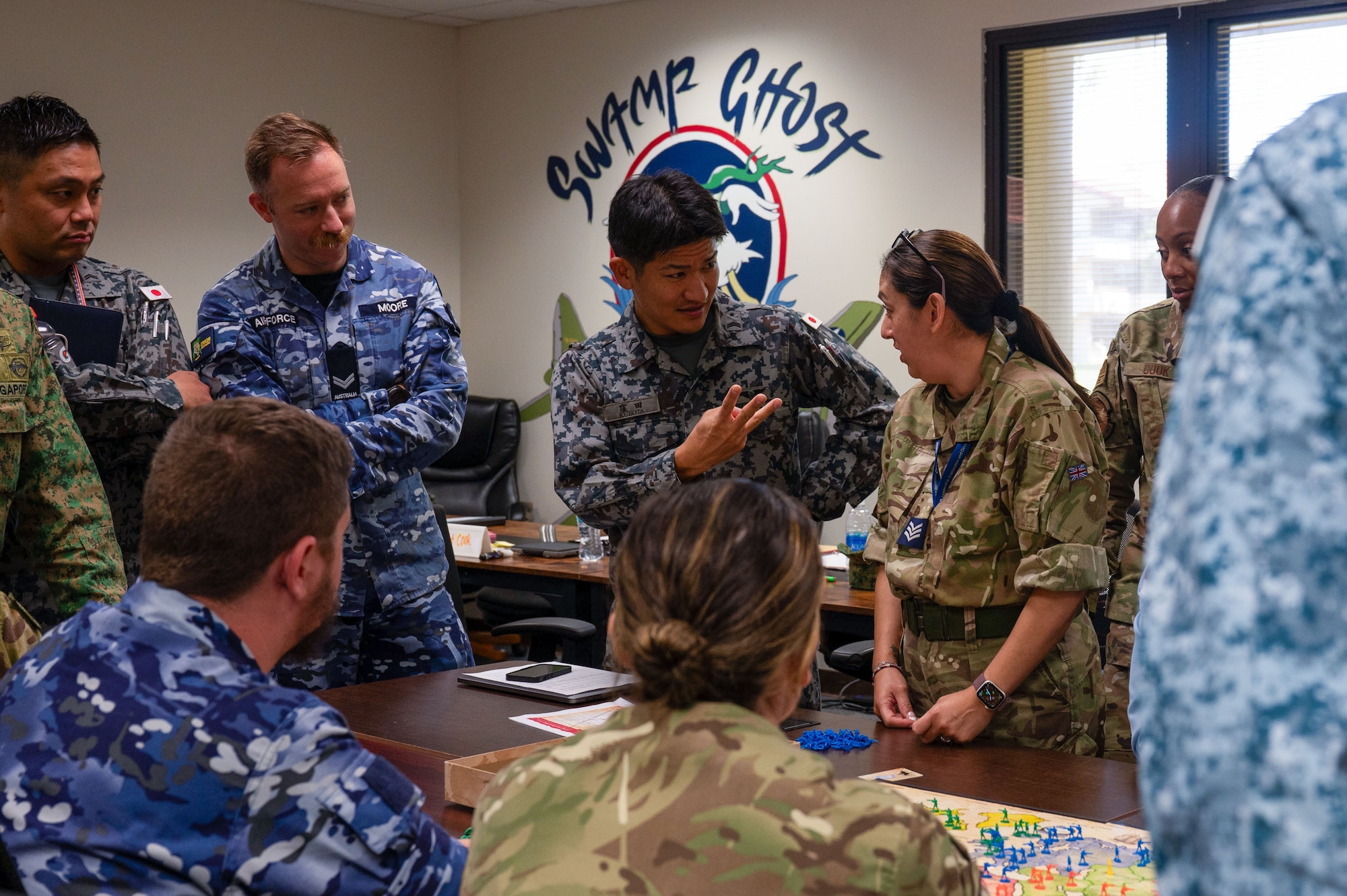 Photo of a group of international air forces' Airmen commuicating