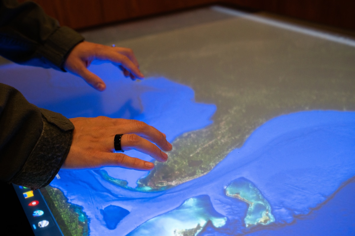 Hands on a computer screen table.
