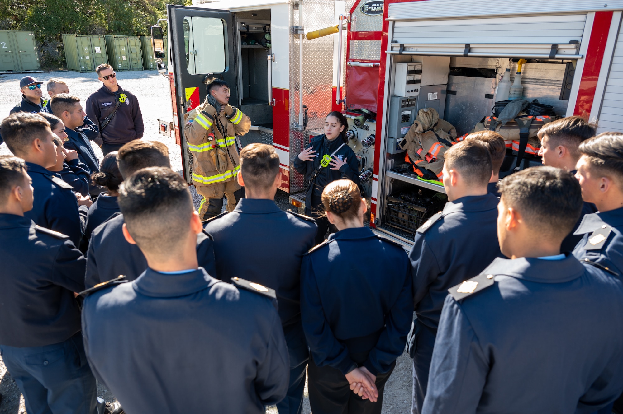 Estefania Makela, 96th Civil Engineer Squadron fire fighter, explains how quickly fire fighters need to don a fire bunker suit to approximately 80 Argentine Air Force Academy cadets and support staff