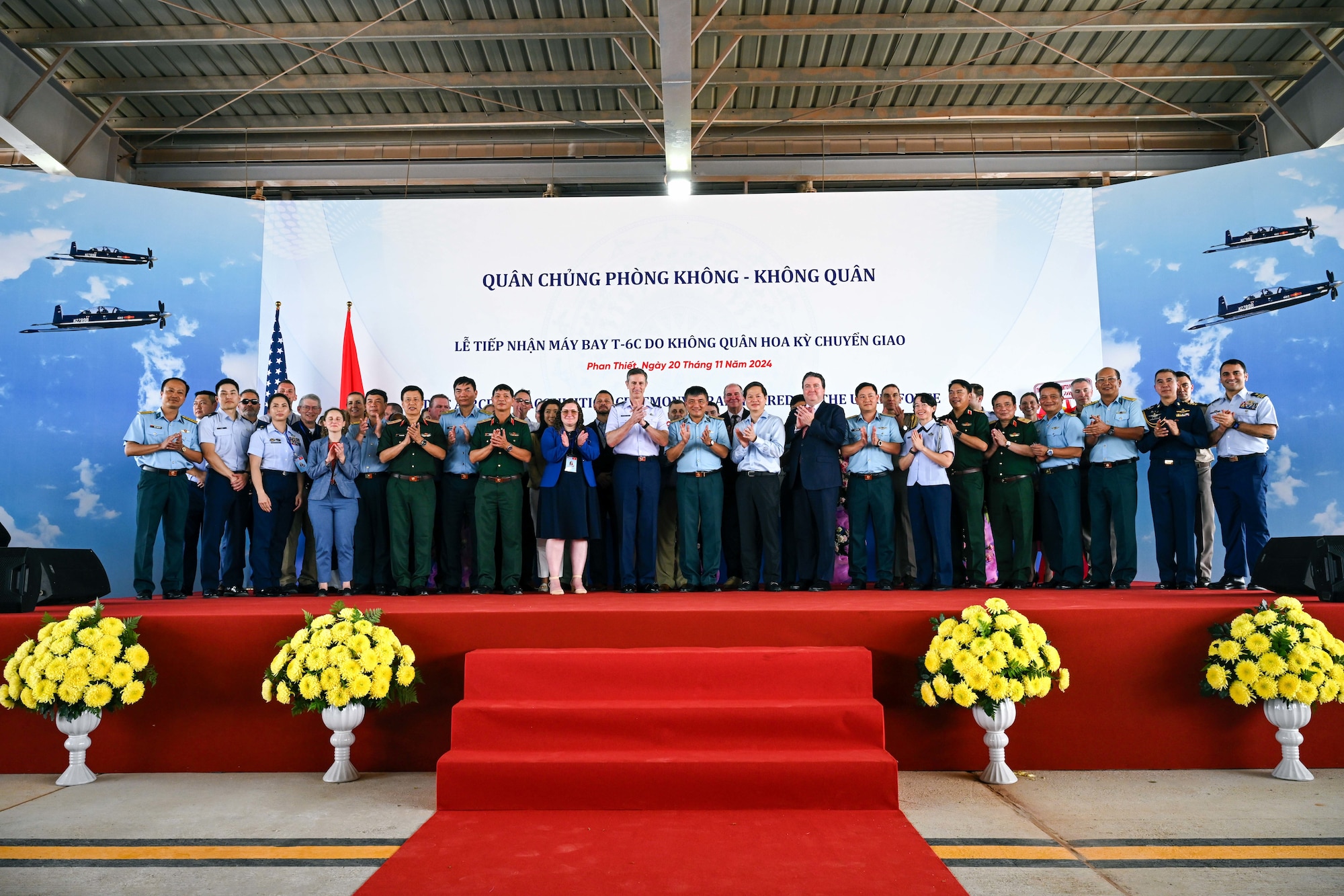 Photo of U.S. and Vietnam military personnel during a T-6C Texan II aircraft delivery