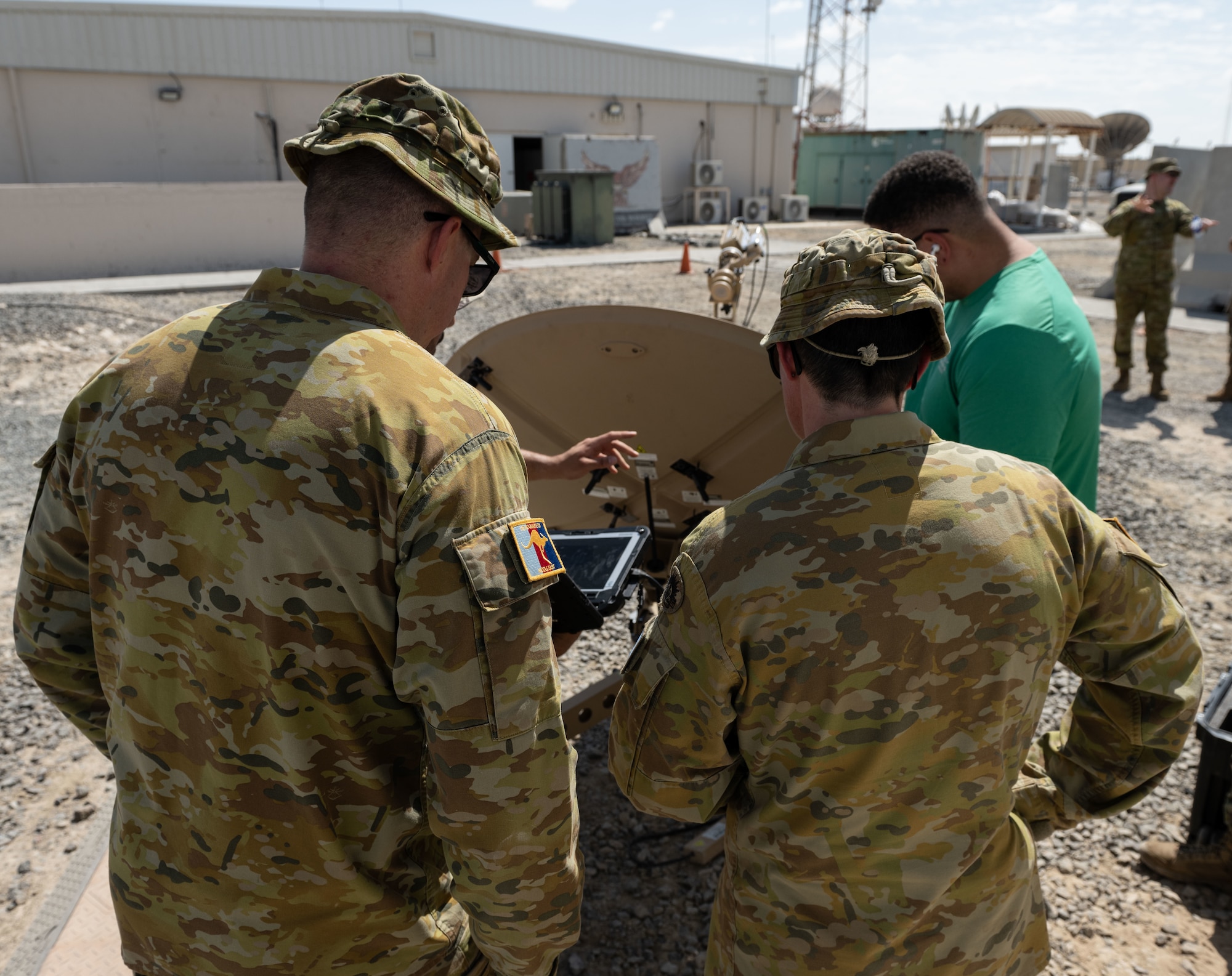 Australian Army and Air Force communications specialists observe as U.S. Air Force communications specialists assemble a Communications Fly Away Kit.