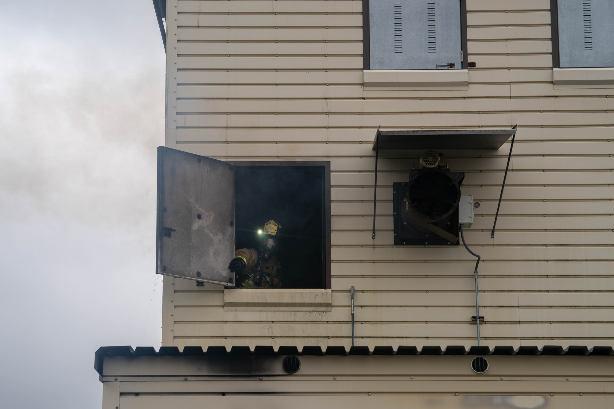 Firefighter opens a window