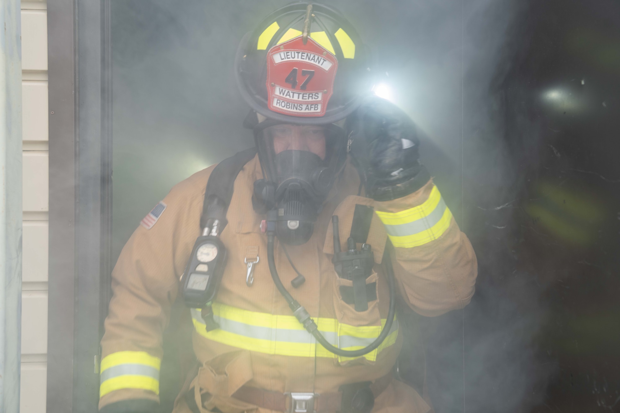 Firefighter walks through smoke while leaving a building