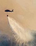 A New York Army National Guard UH-60M Black Hawk helicopter dumps water on the 5,200-acre Jennings Creek Fire in Greenwood Lake, New York, Nov. 15, 2024, while fighting the wildfire on the New York-New Jersey border in Orange County. New York Army National Guard’s aviators spent nine days assisting state and local firefighting crews in containing the fire.