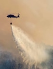 A New York Army National Guard UH-60M Black Hawk helicopter dumps water on the 5,200-acre Jennings Creek Fire in Greenwood Lake, New York, Nov. 15, 2024, while fighting the wildfire on the New York-New Jersey border in Orange County. New York Army National Guard’s aviators spent nine days assisting state and local firefighting crews in containing the fire.