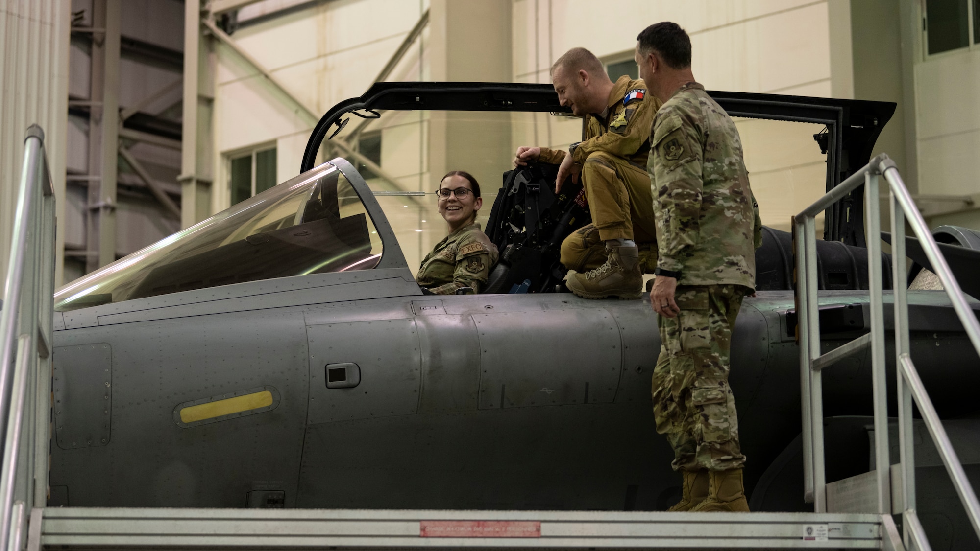 An Airman sits in the cockpit of a French aircraft during a key leadership engagement event.