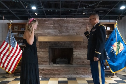 Pvt. Kristen Buck takes the Oath of Enlistment, officiated by her father, Maj. Christopher Buck, after enlisting in the Oklahoma Army National Guard as a religious affairs specialist, Oct. 15, 2024. Kristen continues her family's legacy by following in her father's footsteps, who has been a member of the Oklahoma Army National Guard for the past 25 years. (Oklahoma National Guard photo by Staff Sgt. Reece Heck)