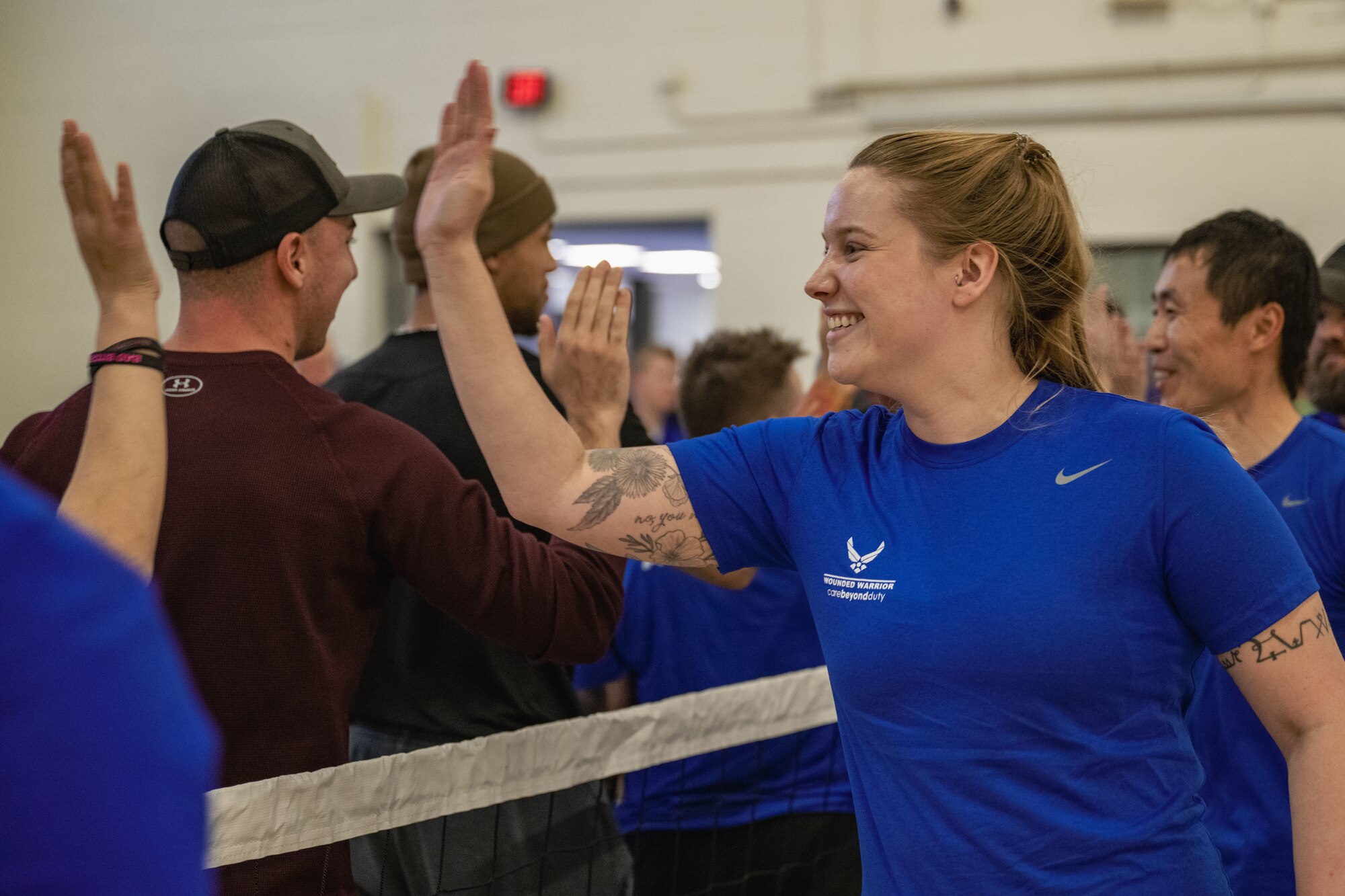 Participants high five each other after a game of sitting volleyball.