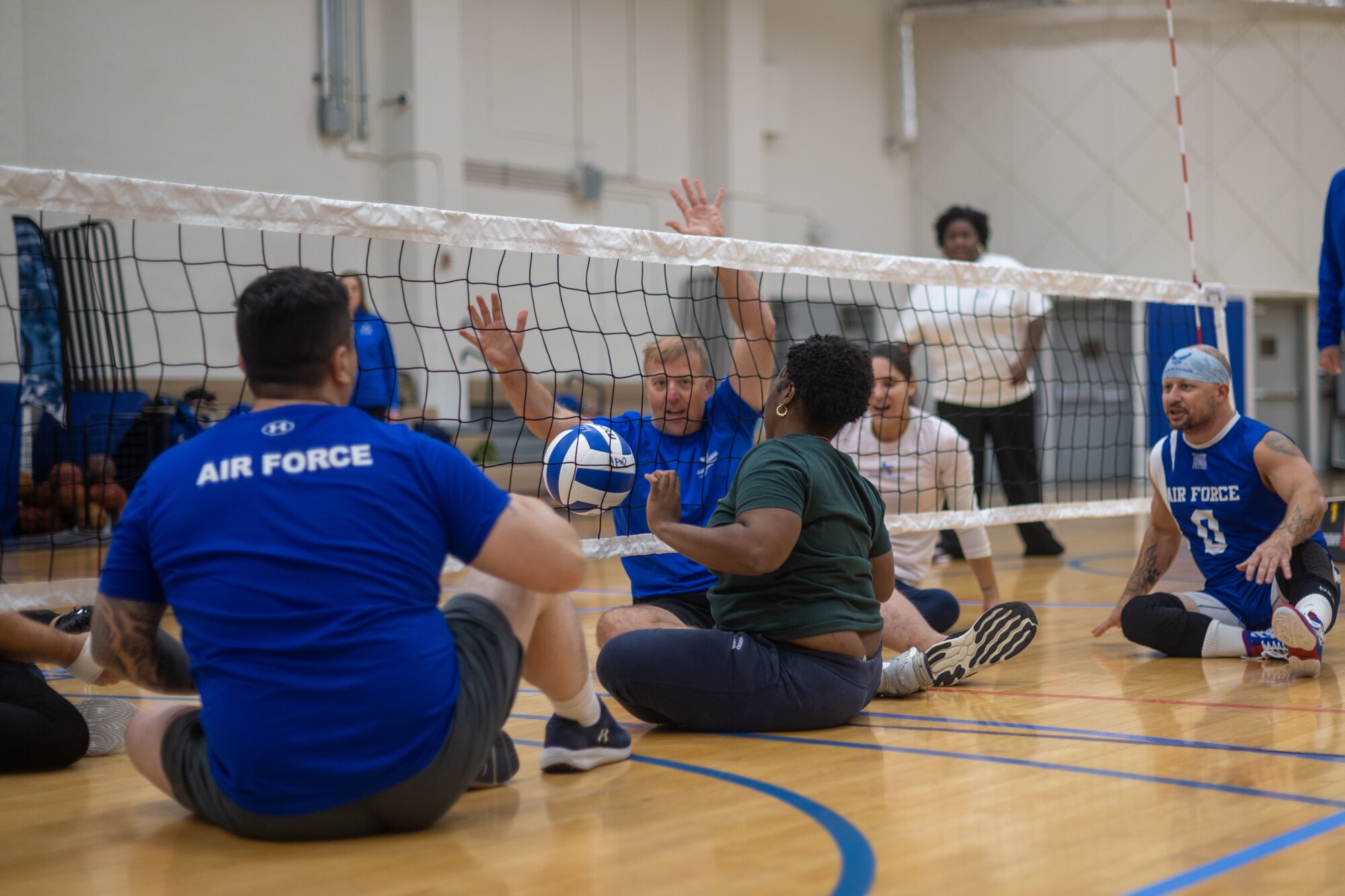 Participants play a game of sitting volleyball.