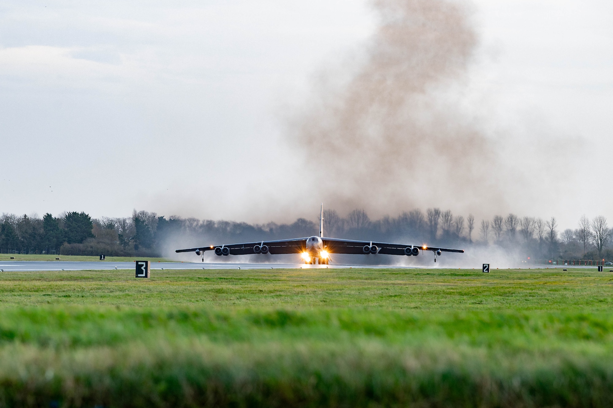Smoke billows behind plane taking off.
