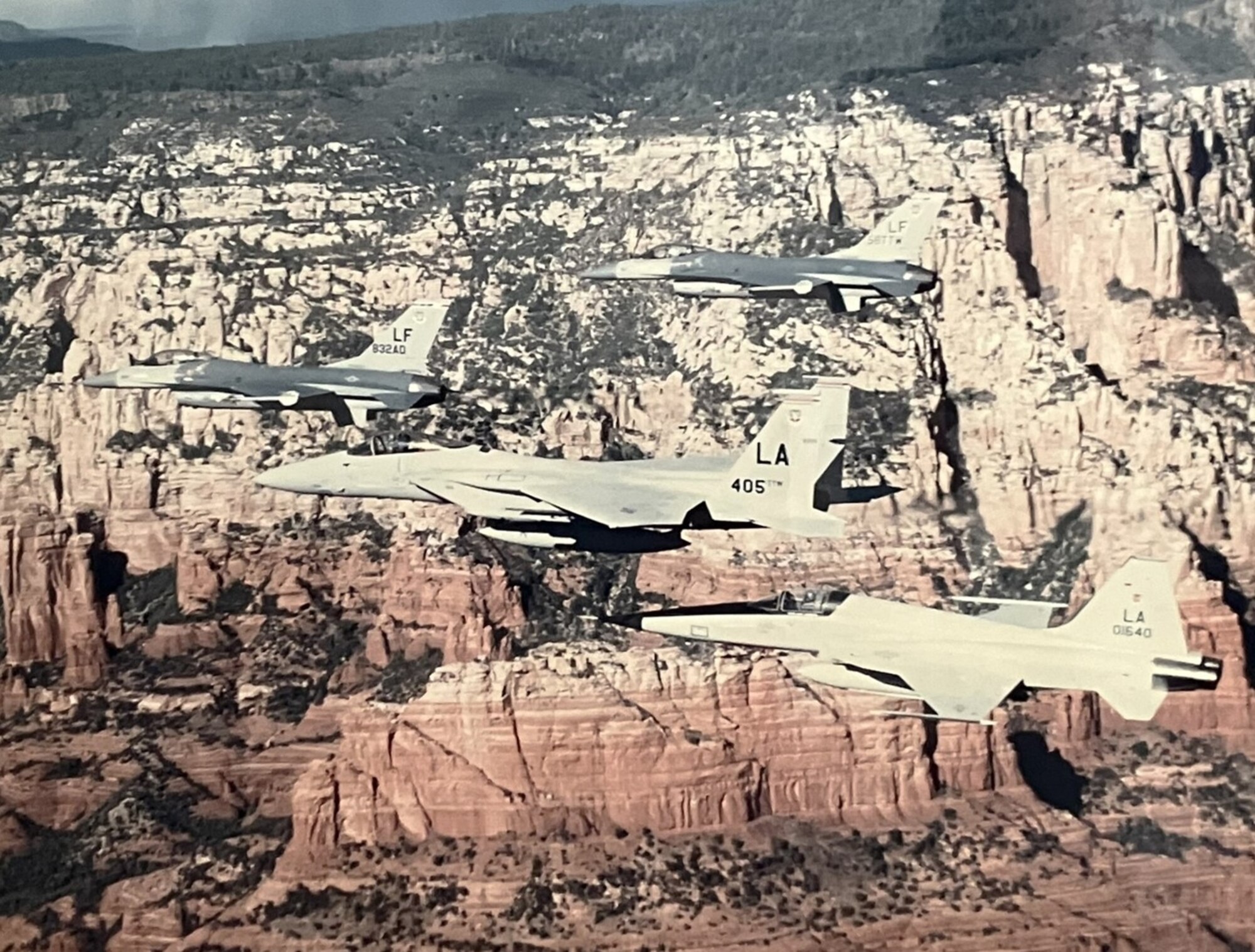 Two U.S. Air Force F-16 Falcons assigned to the 58th Tactical Training Wing, a U.S. Air Force F-15 Eagle assigned to the 405th TTW, and a U.S. Air Force F-5 Tiger fly in formation over Arizona, 1987.