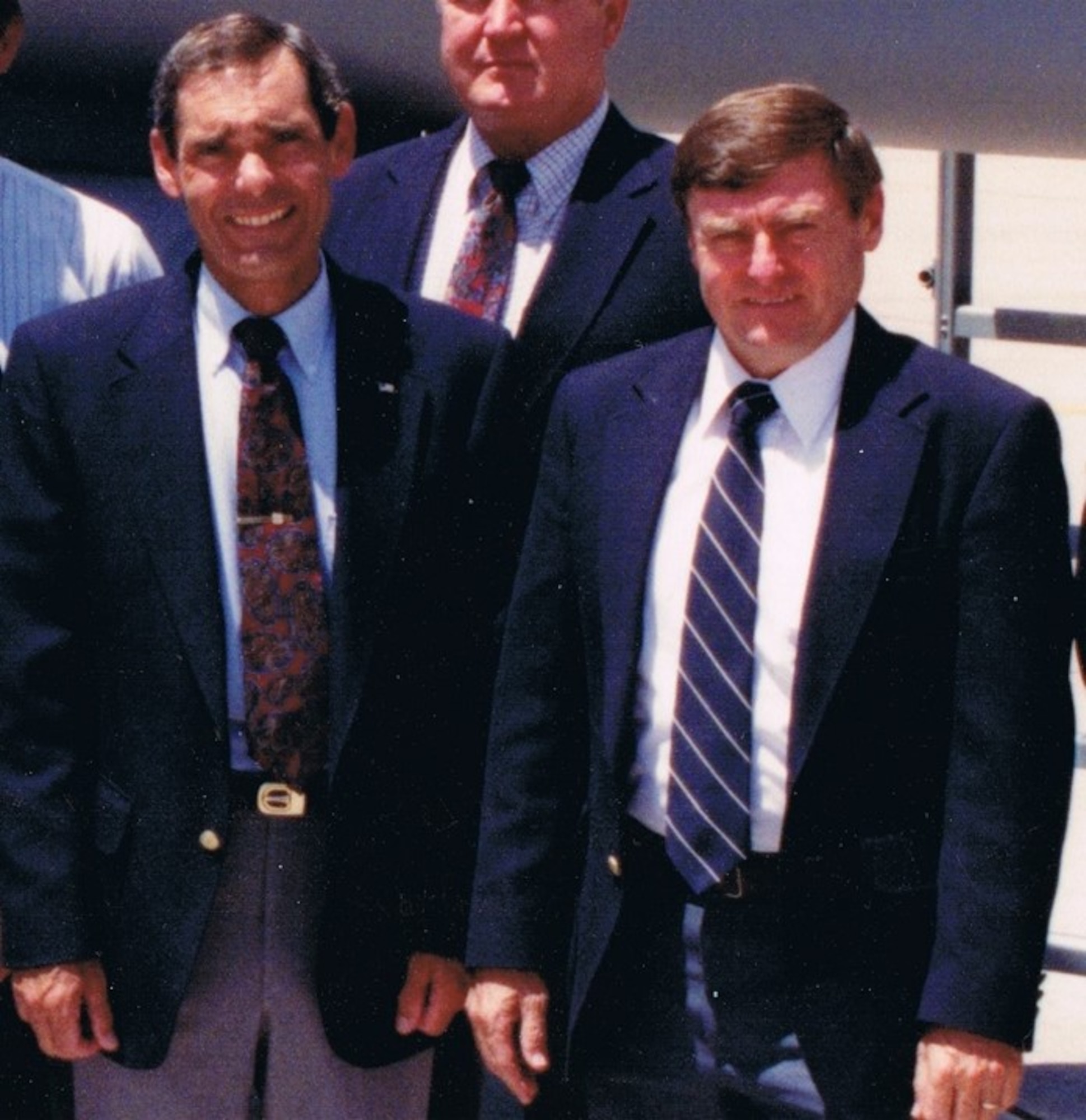 Bruce Cox (left), Simuflite instructor, and Edwin A. “Skip” Hopler (right), Simuflite chief instructor, stand in a group photo of contracted fighter pilot instructors at Luke Air Force Base, Arizona, in 1991.