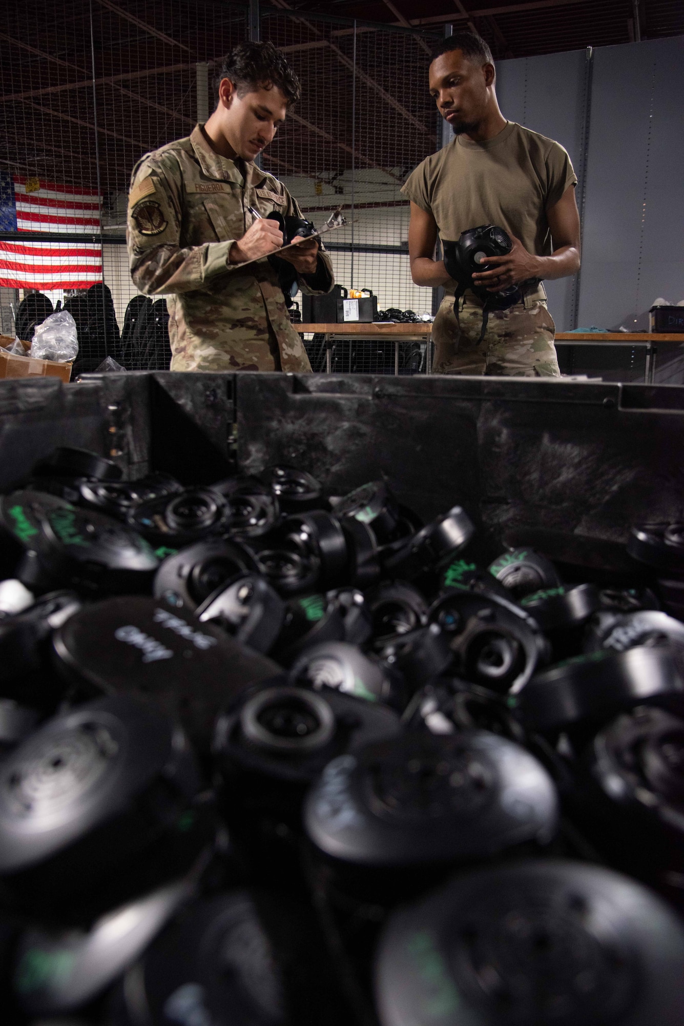 Airman 1st Class Efrain Figueroa, left, 4th Logistics Readiness Squadron individual protective equipment (IPE) apprentice, and Airman 1st Class Stephon Owens, 4th LRS IPE journeyman, log personal protective equipment information.