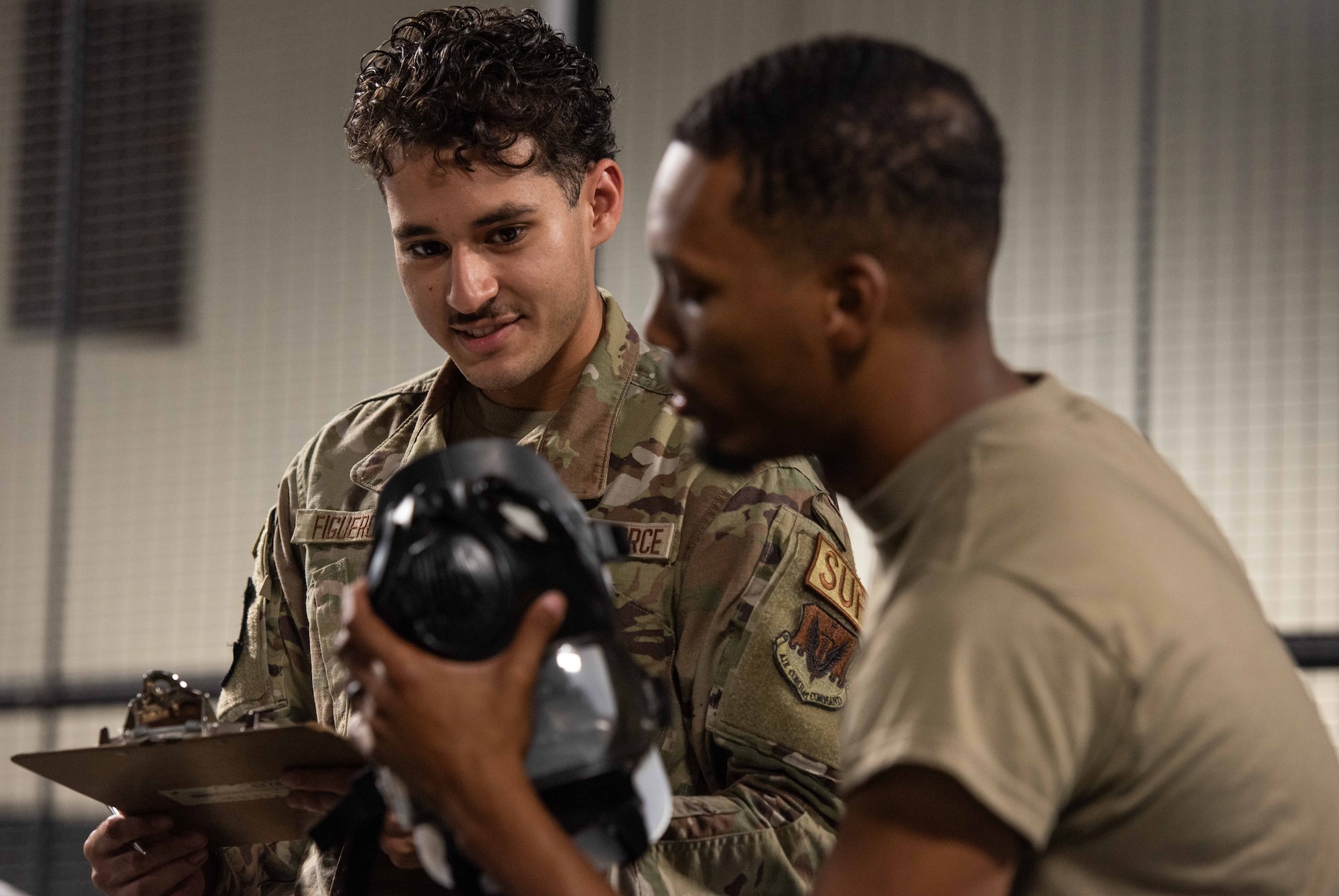 Airman 1st Class Efrain Figueroa, left, 4th Logistics Readiness Squadron Individual Protective Equipment (IPE) apprentice, and Airman 1st Class Stephon Owens, 4th LRS IPE journeyman, log personal protective equipment information.