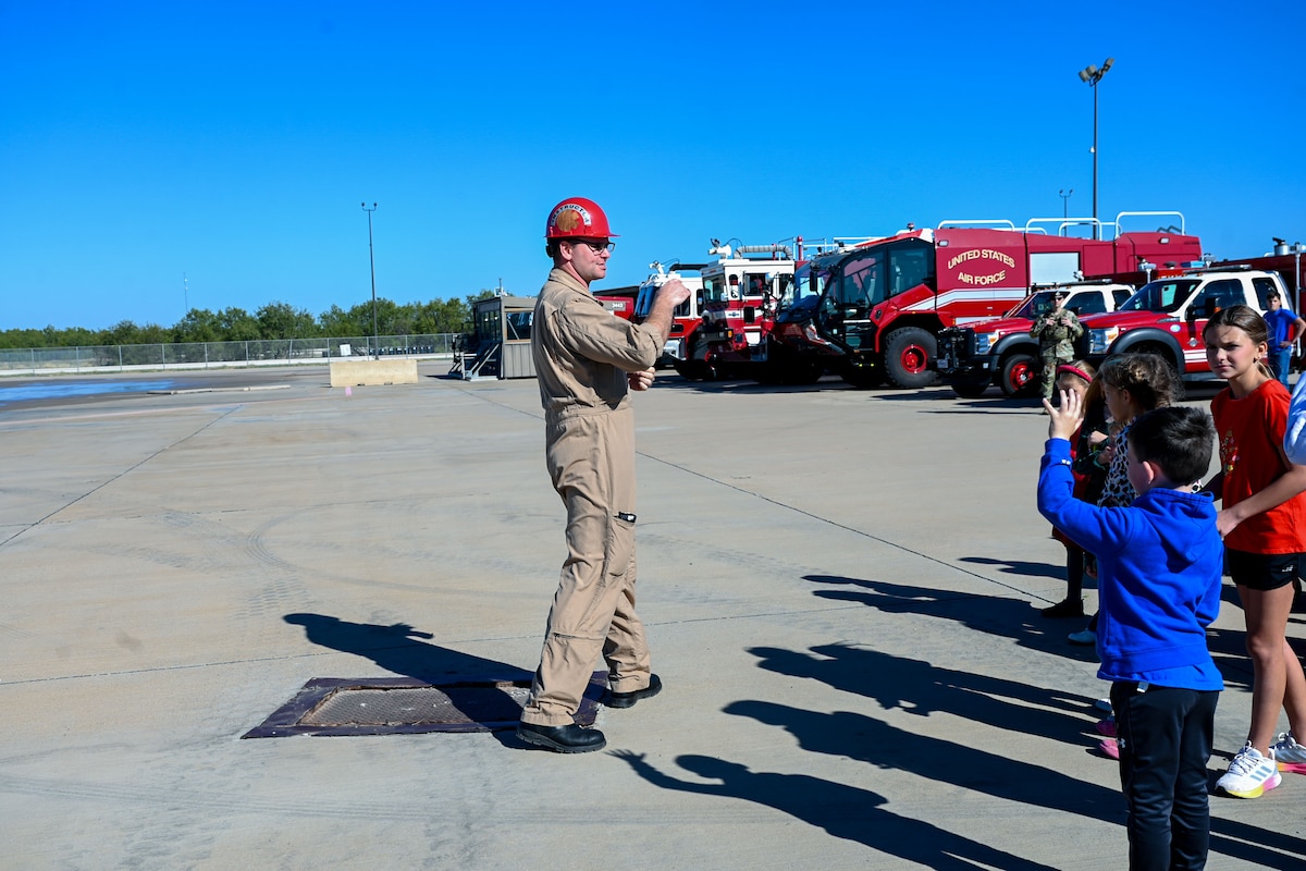 U.S. Air Force Staff Sgt. Robert Kirkpatrick, 312th Training Squadron aircraft rescue firefighting instructor, narrates a live aircraft burn demonstration during the 42nd annual Santa’s Market and 2nd annual Base Open House at the Louis F. Garland Department of Defense Fire Academy, Goodfellow Air Force Base, Texas, Nov. 23, 2024. Santa’s Market invited the community on base to learn more about Goodfellow's mission. (U.S. Air Force photo Airman 1st Class Evelyn J. D’Errico)