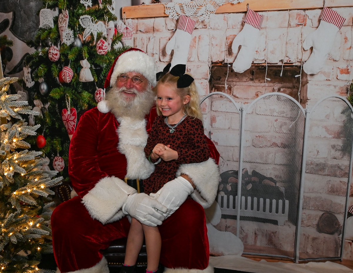 A Santa’s Market attendee takes a photo with Santa Claus during the 42nd annual Santa’s Market and 2nd annual Base Open House at the Louis F. Garland Department of Defense Fire Academy, Goodfellow Air Force Base, Texas, Nov. 23, 2024. Santa’s Market originated as a small holiday craft market for training students on base and has grown to a large-scale community experience with more than 70 vendors. (U.S. Air Force photo Airman 1st Class Evelyn J. D’Errico)
