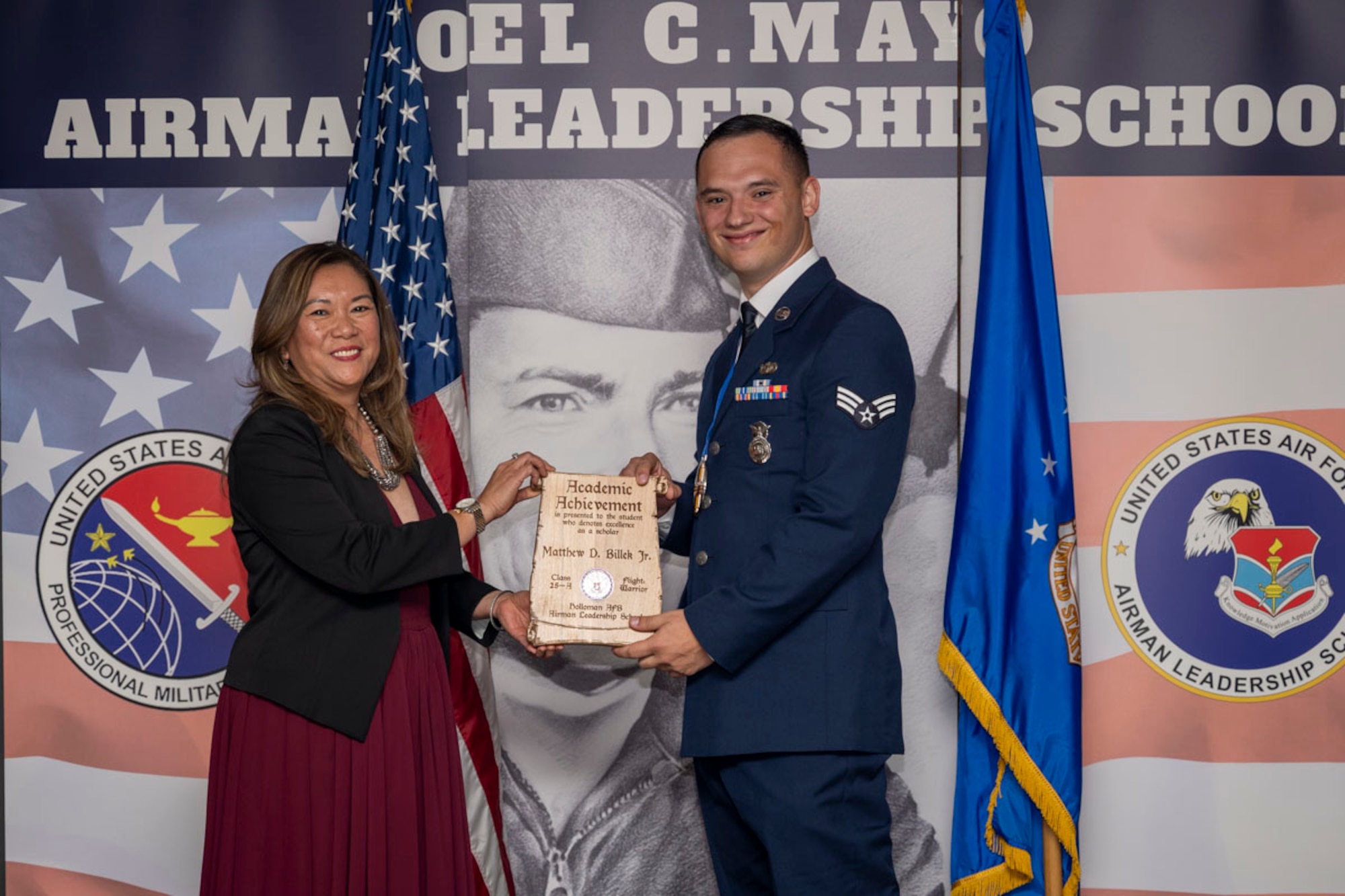 U.S. Air Force Senior Airman Matthew Billek right, Airman Leadership Graduate, accepts Academic Achievement Award from Mrs. Lany Cooper, during the graduation of Joel C. Mayo ALS Class 25-A at Holloman Air Force Base, New Mexico, Nov. 21, 2024. The academic award is presented to the student with the highest overall average on all academic evaluations and demonstrations of leadership. (U.S. Air Force photo by Airman 1st Class Michelle Ferrari)