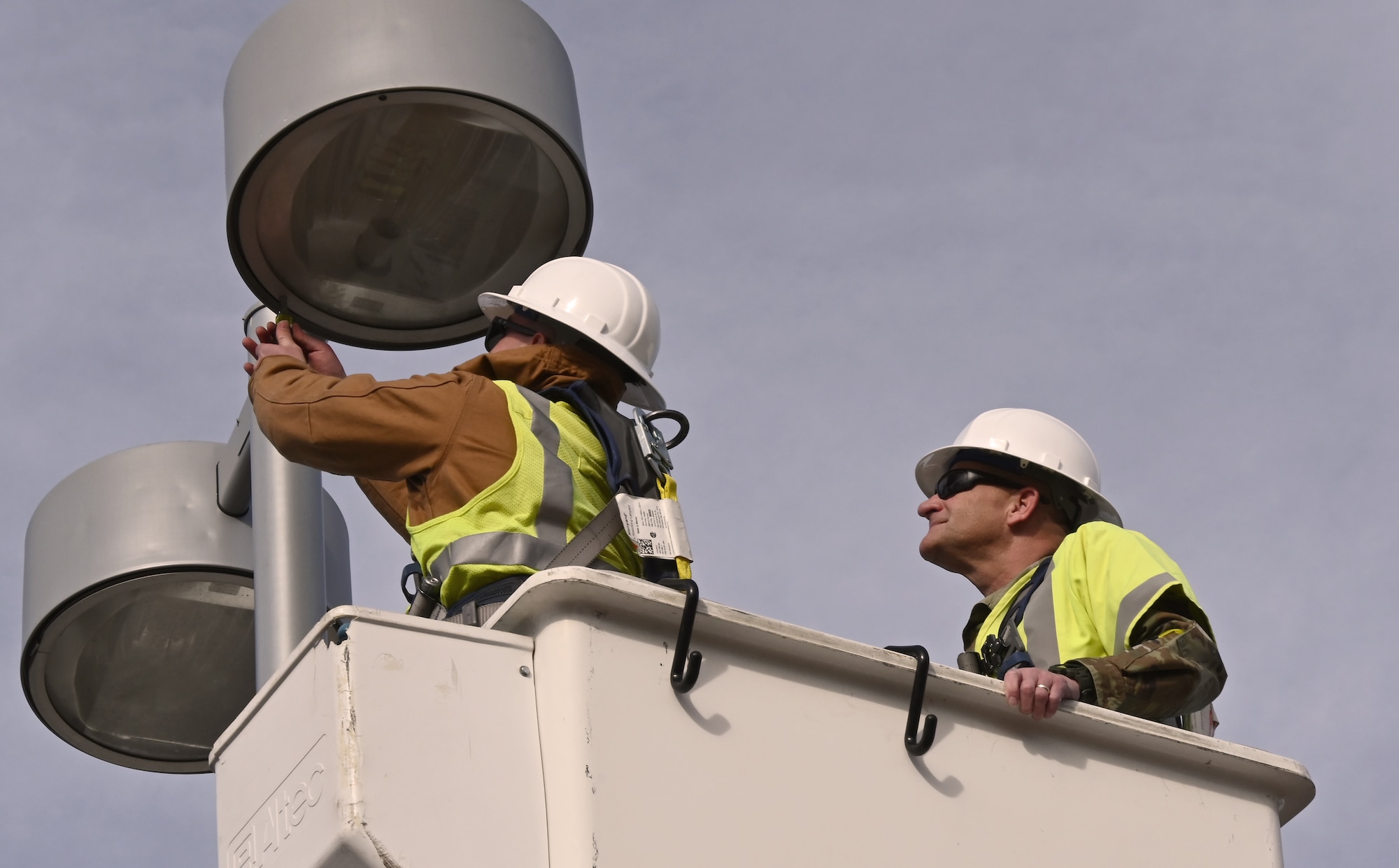 U.S. Space Force Col. Kenneth Klock, Space Base Delta 1 commander, assists U.S. Air Force Staff Sgt. Tyler Erwin, 21st Civil Engineer Squadron electrical systems supervisor, in removing a ballast from a parking lot light as part of an immersion tour on Peterson Space Force Base, Colorado, Nov. 21, 2024. The 21st CES oversees the maintenance of $2.2 billion in weapons systems infrastructure for the USSF and is critical to its functionality. (U.S. Space Force photo by Christopher L. Ingersoll)