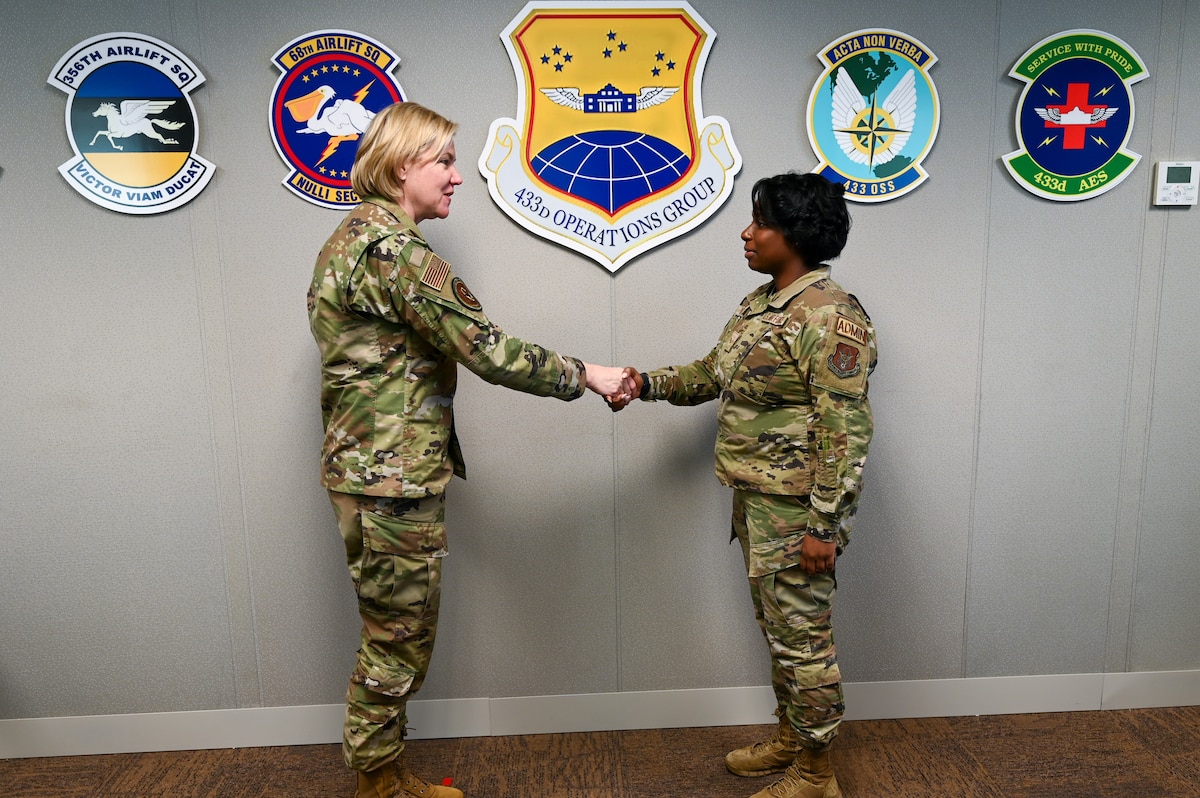 Senior Airman Ashley Burrell, a 433rd Operations Group administration technician, accepts a commander’s coin from Maj. Gen. C. McCauley von Hoffman, Deputy to the Chief of Air Force Reserve, Headquarters U.S. Air Force, at Joint Base San Antonio-Lackland, Texas, Nov. 19, 2024.