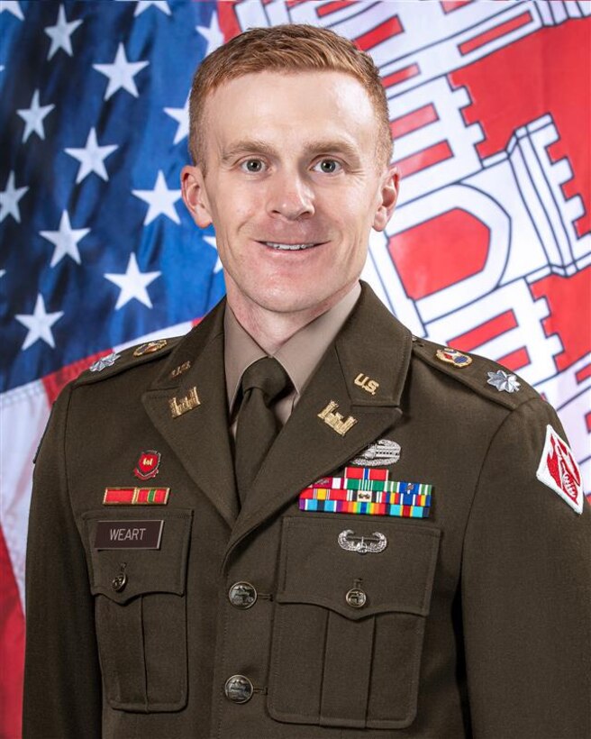 Photo of Lieutenant Colonel David Weart in his Army mess dress uniform in front of the United States and United States Corps of Engineers flags.