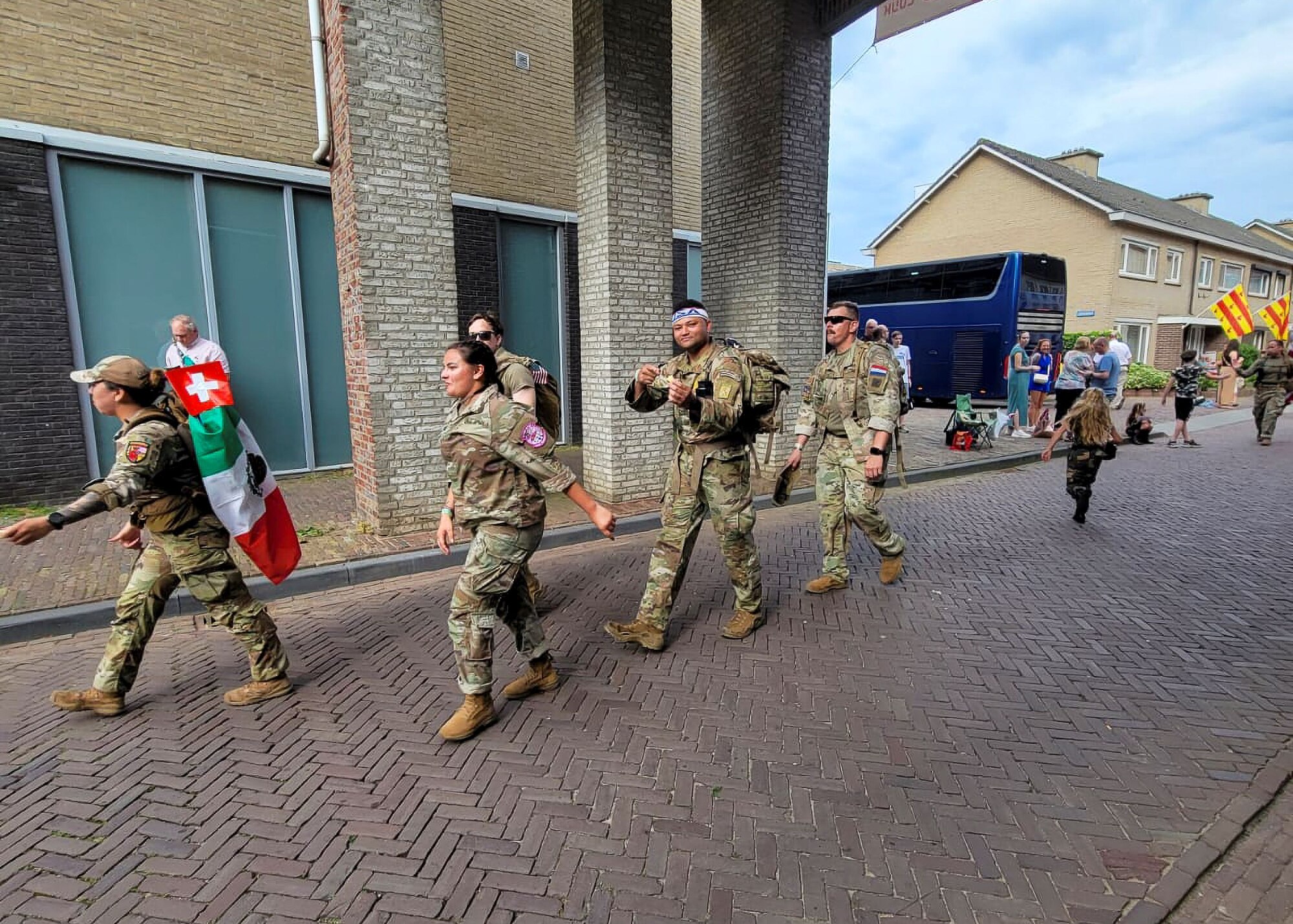 Tech. Sgt. Alexander Bertsch, an air traffic control supervisor in the 412th Operational Support Squadron here, sports a USA headband as he walks along a village street with teammates as part of the Nijmegan March, the world’s largest multiple-day marching event. Participants must complete a 100-mile journey over four days, with military members required to wear their uniform and carry a 22-pound rucksack.