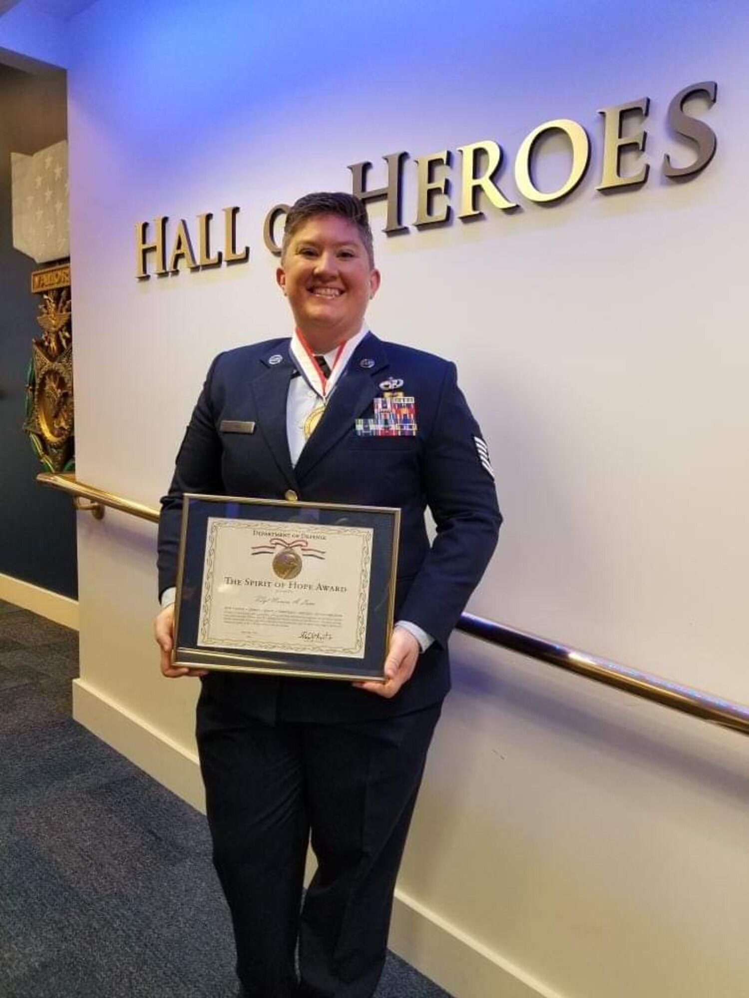 A person poses with an award.