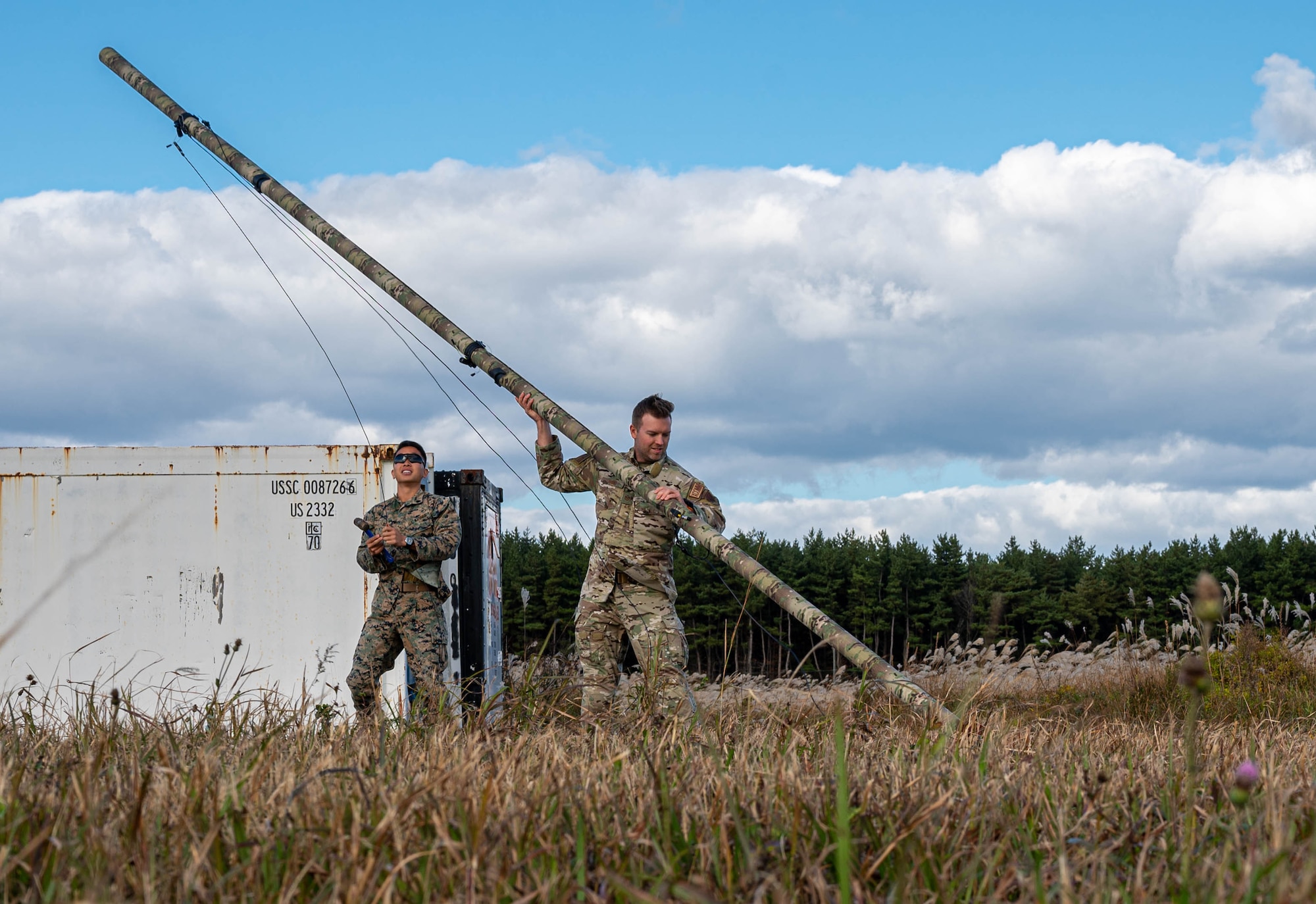U.S. Marine Corps Sgt. Tae Burgess, left, 1st Marine Aircraft Wing Air Defense Company A/B Radar aviation radar technician crew chief, and U.S. Air Force Tech. Sgt. Charles Abbey, 752nd Operations Support Squadron Tactical Operations Center - Light Pathfinder team lead, erect a Rola Tube Antenna during exercise Keen Sword 25 at Misawa Air Base, Japan, Oct. 28, 2024.