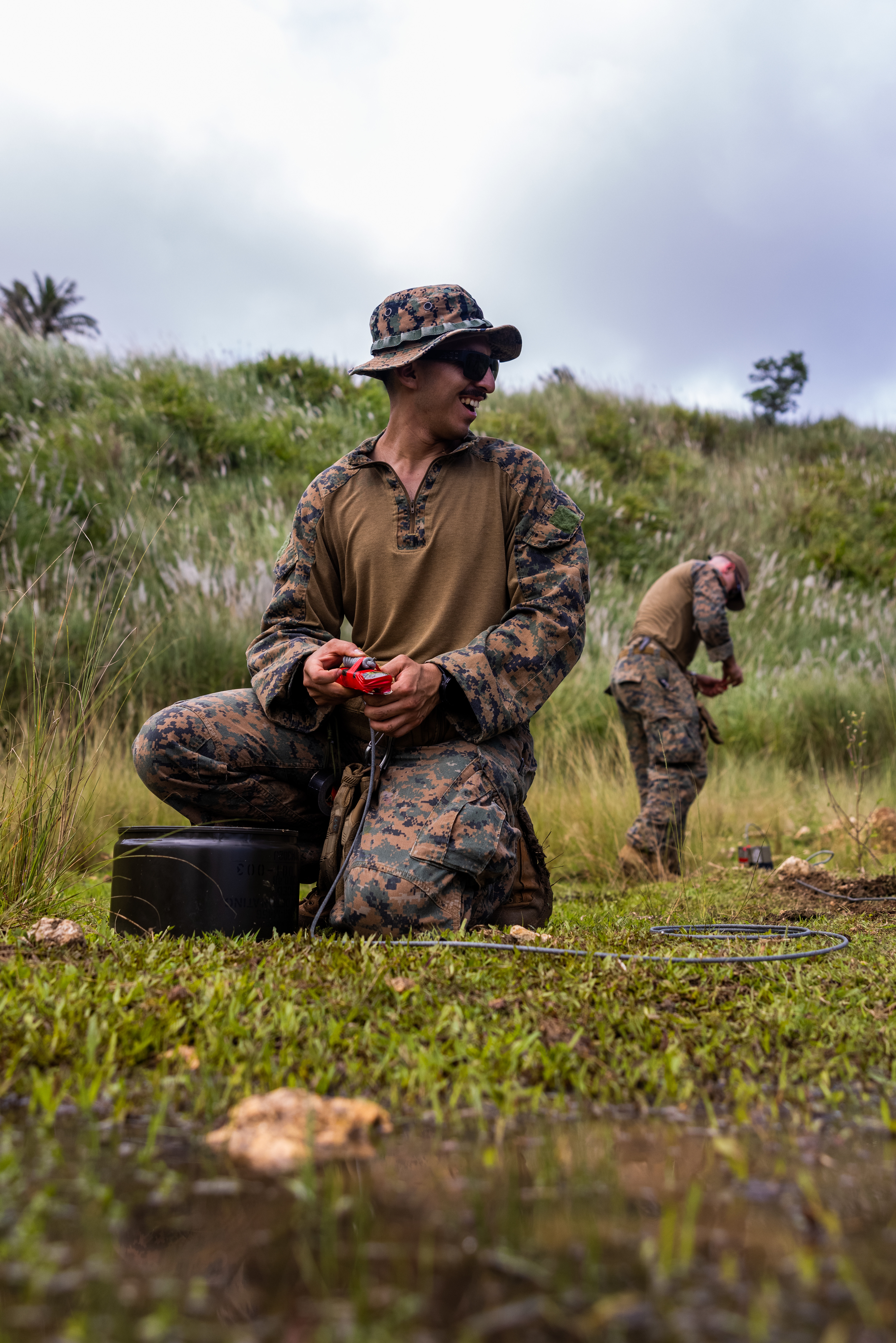 U.S. Marine Corps Sgt. Sergio Hernandez, explosive ordnance disposal technician, 15th Marine Expeditionary Unit, wraps detonation cord around C4 during a joint service EOD range on Naval Base Guam Ordnance Annex, Guam, Oct. 31, 2024. MCB Camp Blaz and 

 15th MEU Marines participated in a joint service EOD range in order to increase tactical proficiency, as well as strengthen the interservice connection between EOD teams. (Marine Corps photo by Cpl. Ryan Little)