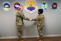 Senior Airman Ashley Burrell, a 433rd Operations Group administration technician, accepts a commander’s coin from Maj. Gen. C. McCauley von Hoffman, Deputy to the Chief of Air Force Reserve, Headquarters U.S. Air Force, at Joint Base San Antonio-Lackland, Texas, Nov. 19, 2024.