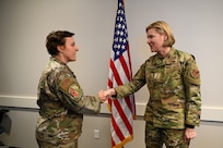 Senior Master Sgt. Catherine Falcon, 433rd Security Forces Squadron superintendent, accepts a commander’s coin from Maj. Gen. C. McCauley von Hoffman, Deputy to the Chief of Air Force Reserve, Headquarters U.S. Air Force, at Joint Base San Antonio-Lackland, Texas, Nov. 19, 2024.