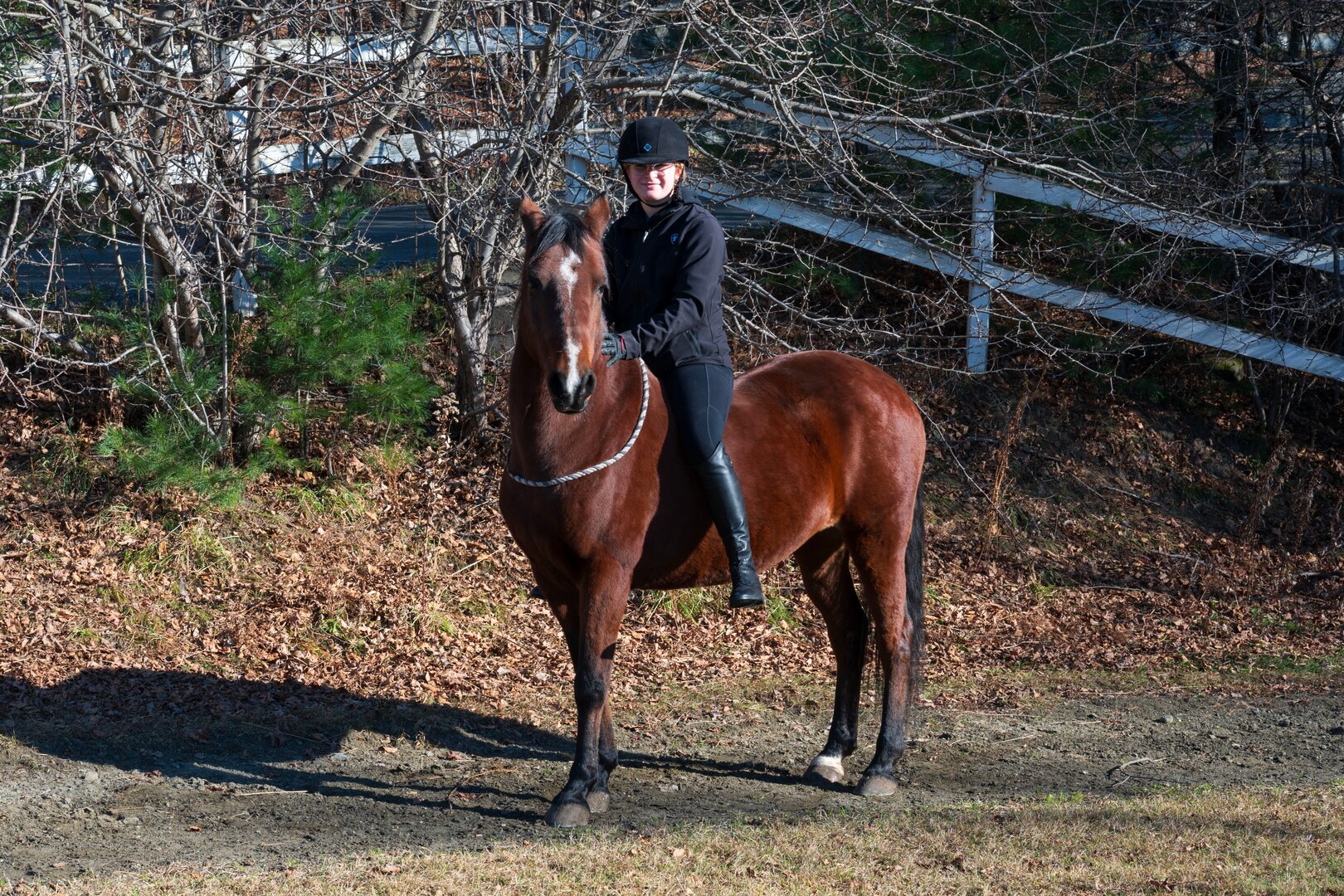 Photo of U.S. Air Force Senior Airman Analie Choquette, a Transportation Movement Operations Specialist assigned to the 158th Fighter Wing, posing with her horse, Prada, at a horse farm in Orange, Vermont, Nov. 17, 2024.