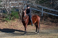 Photo of U.S. Air Force Senior Airman Analie Choquette, a Transportation Movement Operations Specialist assigned to the 158th Fighter Wing, posing with her horse, Prada, at a horse farm in Orange, Vermont, Nov. 17, 2024.