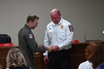 Kevin Lewis, fire chief at Holley-Navarre Fire District, recognizes U.S. Air Force 1st Lt. Christian Munoz, assigned to the 492nd Special Operations Wing, for his efforts in an off-base rescue, at Holley-Navarre Fire Station 45 in Navarre Florida, Nov. 25, 2024.