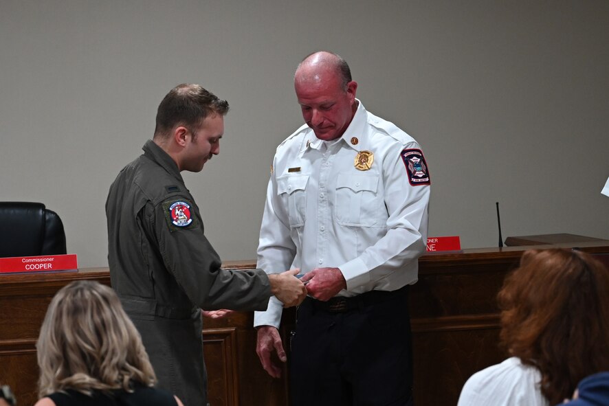 Kevin Lewis, fire chief at Holley-Navarre Fire District, recognizes U.S. Air Force 1st Lt. Christian Munoz, assigned to the 492nd Special Operations Wing, for his efforts in an off-base rescue, at Holley-Navarre Fire Station 45 in Navarre Florida, Nov. 25, 2024.