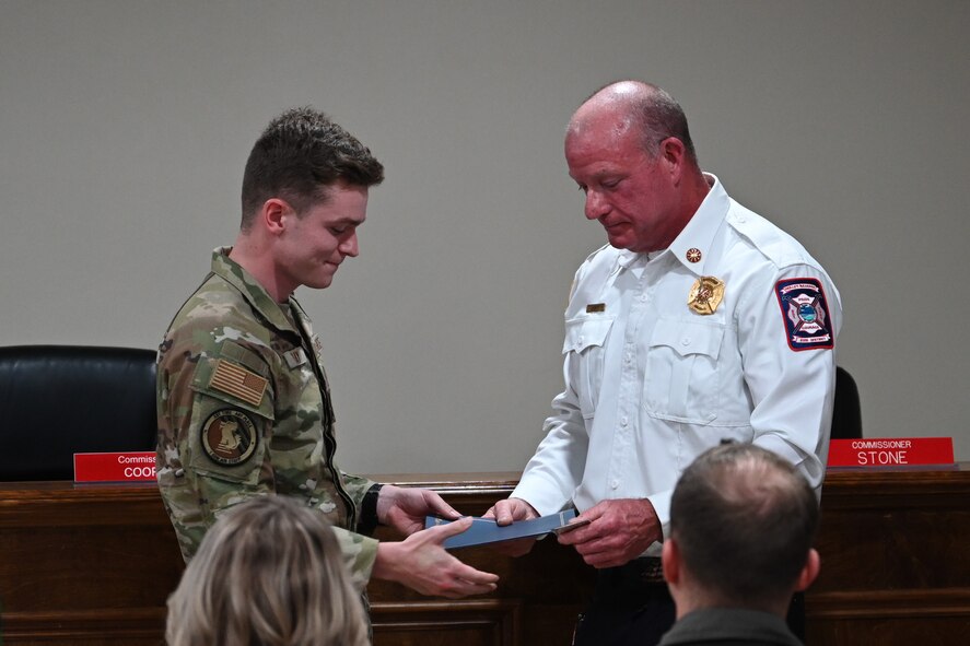 Kevin Lewis, fire chief at Holley-Navarre Fire District, recognizes U.S. Air Force Senior Airman Kyle Hiday, assigned to the 1st Special Operations Wing, for his efforts in an off-base rescue at Holley-Navarre Fire Station 45 in Navarre Florida, Nov. 25, 2024.