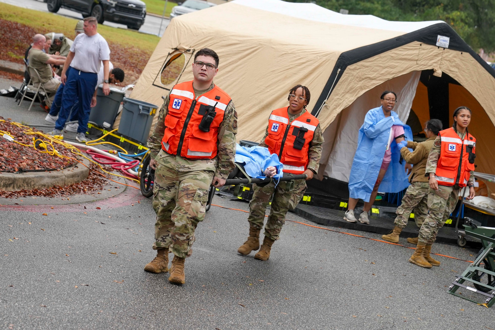 8th Medical Group Manpower team members transport a patient from the decontamination wash down tent to a nearby triage area for medical treatment during a mass casualty decontamination drill conducted at Robins Air Force Base, Georgia, Nov. 20, 2024