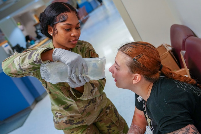 Airman 1st Class Jasmie Holston, 78th Medical Group aerospace medical technician, performs a simulated eye washing to Senior Airman Makaila Cline, 78th Medical Group bioenvironmental engineering technician, during a mass casualty decontamination drill conducted at Robins Air Force Base, Georgia, Nov. 20, 2024