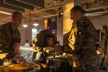 U.S. Marine Corps Sgt. Maj. Oranjel Leavy, center, sergeant major of Marine Corps Recruit Depot San Diego and the Western Recruiting Region, and Sgt. Maj. Thomas Bachman, left, sergeant major of Headquarters and Service Battalion, serve food to Staff Sgt. Melissa Karnath, a communication strategy and operations chief with Headquarters Company, at a friendsgiving event coordinated by the Depot Single Marine Program at Marine Corps Recruit Depot San Diego, California, Nov. 20, 2024. Friendsgiving is part of Spiritual Fitness Month, The Depot celebrated Spiritual Fitness Month, a program implemented to bring inner strength from higher purpose, with a friendsgiving event. MCRDSD is the first Marine Corps base to implement the Spiritual Fitness Month program. (U.S. Marine Corps photo by Cpl. Alexander O. Devereux)