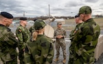 U.S. Army Lt. Col. Elsa Canales, support operations officer for the 369th Sustainment Brigade, New York National Guard, speaks with members of the Swedish military as she gives them a tour of the 42nd Infantry Division’s command post exercise operations at Fort Indiantown Gap, Pa., Nov. 21, 2024.  The New York National Guard and Sweden entered into an official partnership as part of the National Guard’s State Partnership Program in July, focusing on shared values and training to build relationships and capabilities for both military forces.