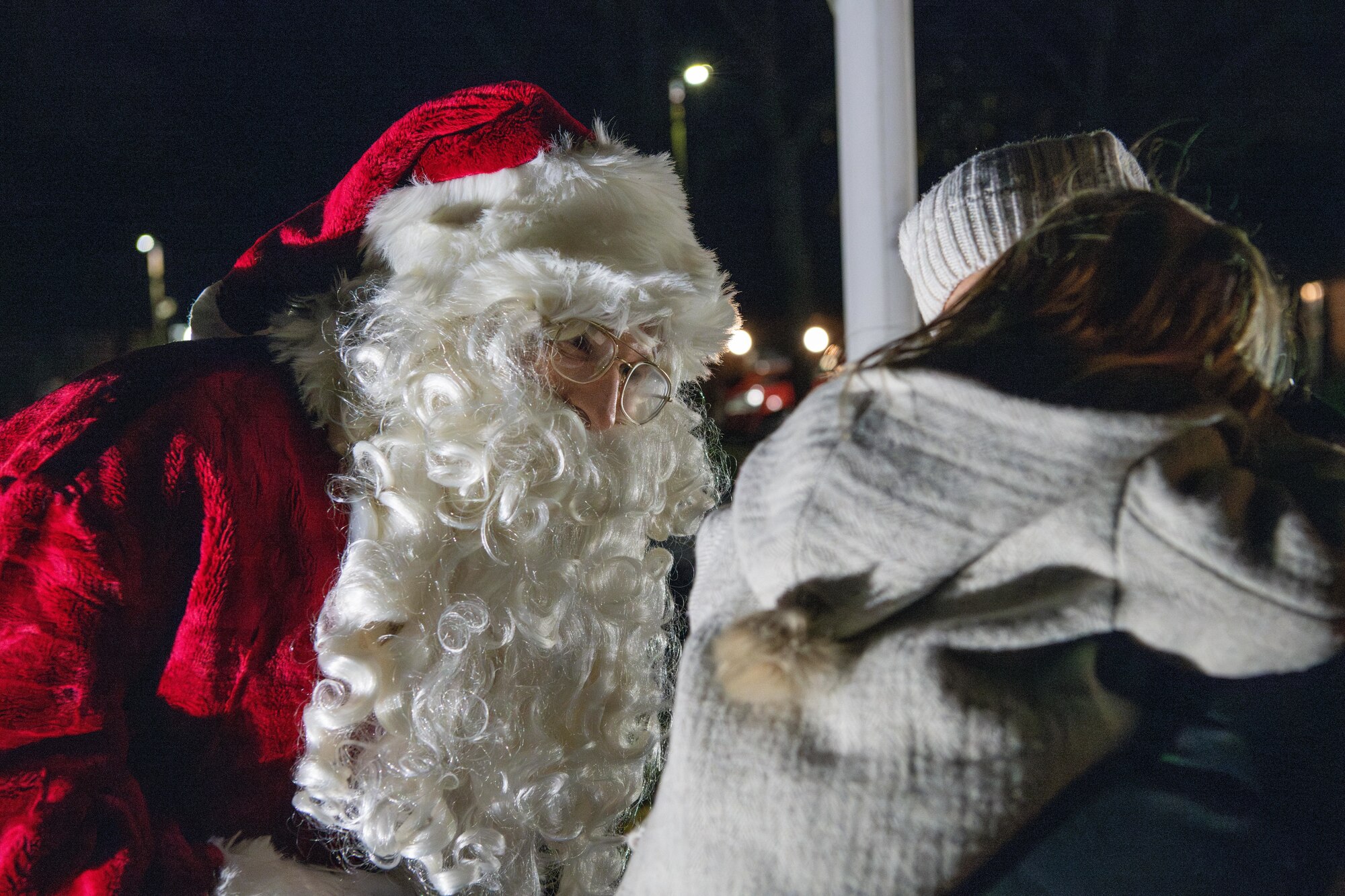 Santa Claus speaks with a child during a holiday market