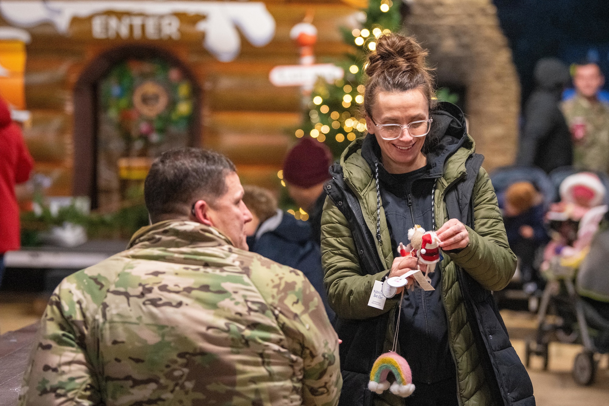 A shopper admires Christmas ornaments at a holiday market