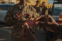 U.S. Marine Corps Brig. Gen. James A. Ryans II, commanding general of Marine Corps Recruit Depot San Diego and the Western Recruiting Region, holds a challenge coin presented by Maj. Gen. James B. Wellons, the commanding general of 3rd Marine Aircraft Wing, during a visit to MCRD San Diego, Nov. 18, 2024.  Wellons and his staff visited MCRD San Diego to observe training and learn how MCRDSD and WRR operates. (U.S. Marine Corps photo by Lance Cpl. Janell B. Alvarez)