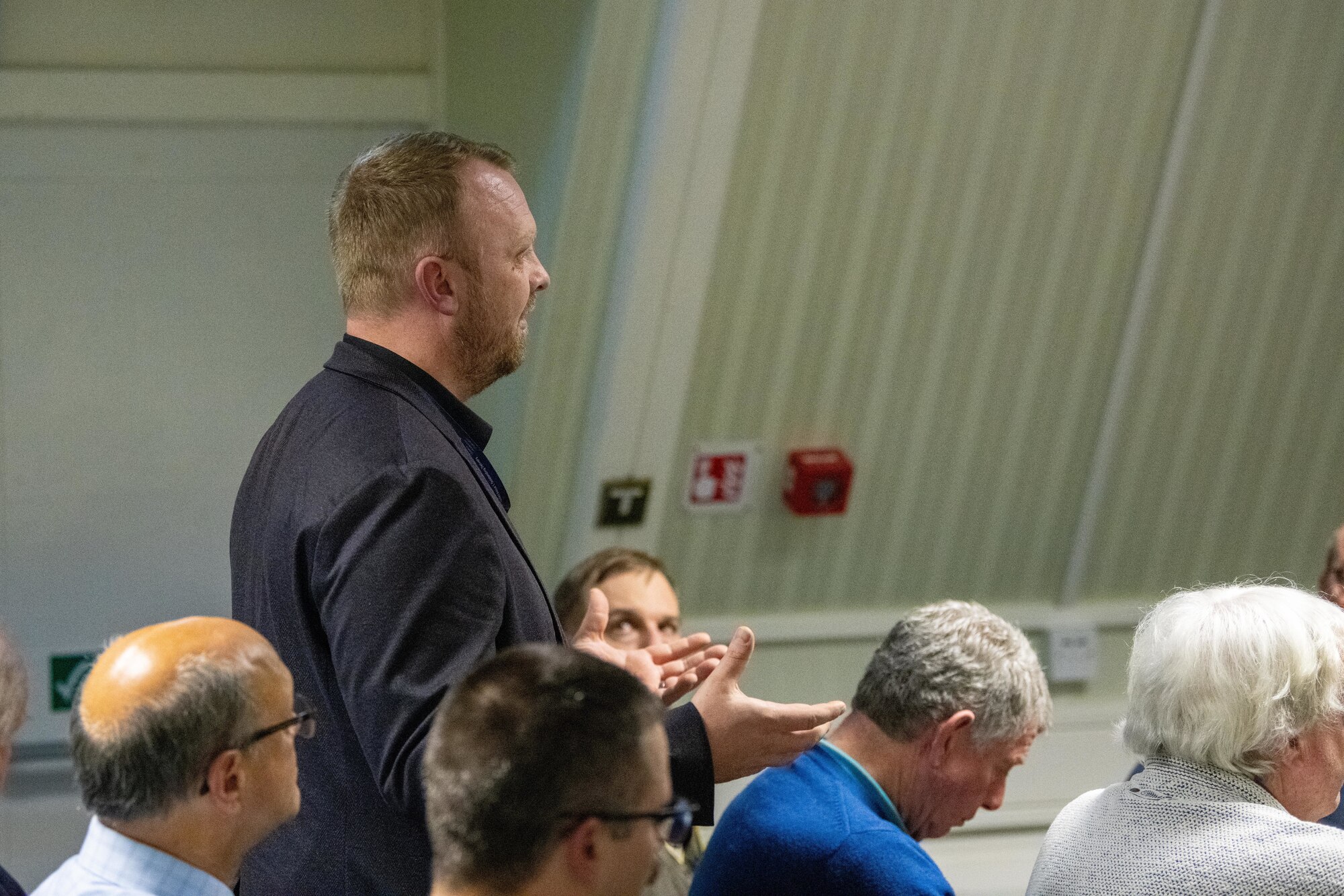 An attendee asks a question during an information evening