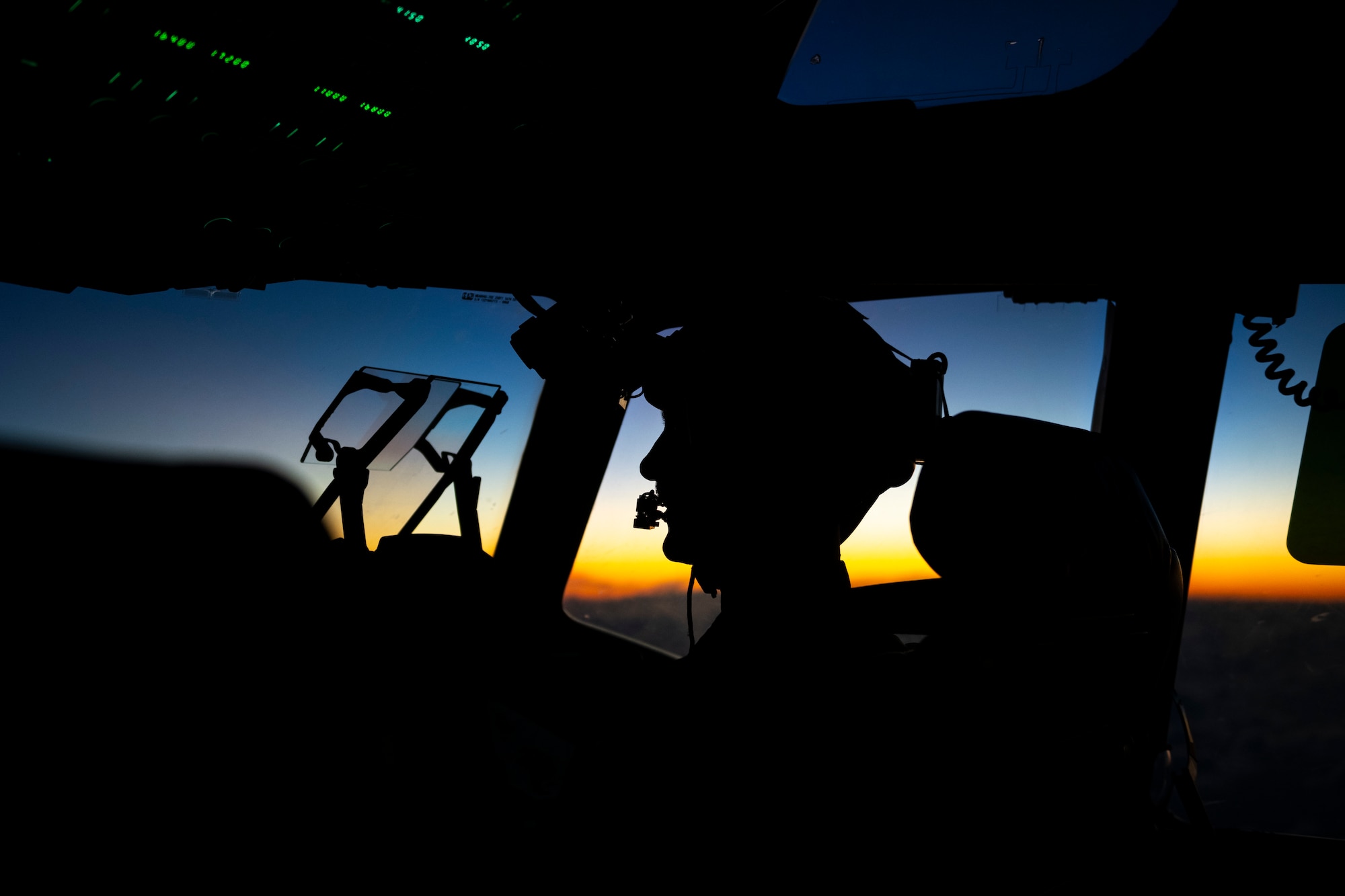 A U.S. Air Force pilot flies a C-17 Globemaster III at night