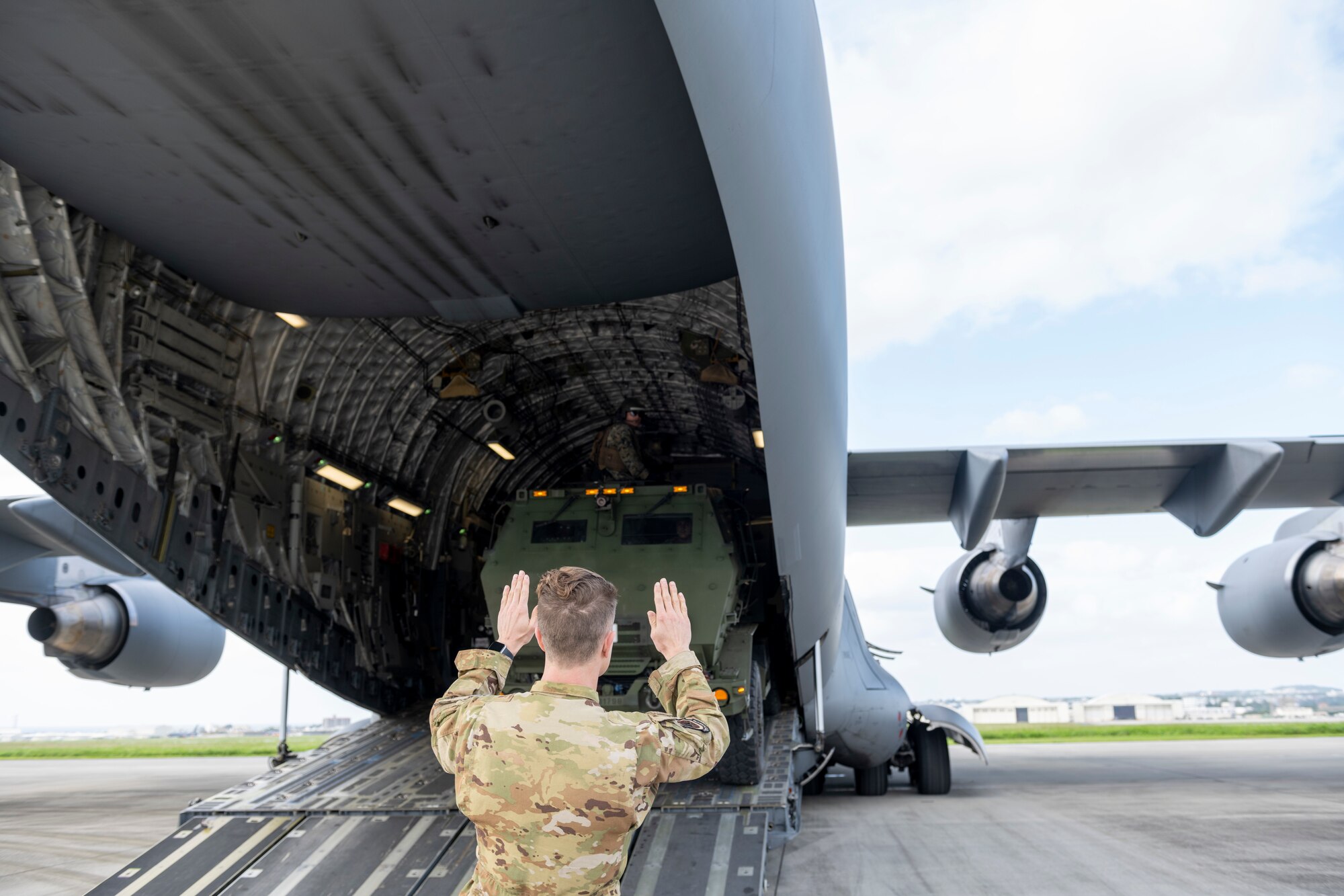 A U.S. Air Force Airman loads a vehicle on to a C-17 Globemaster III