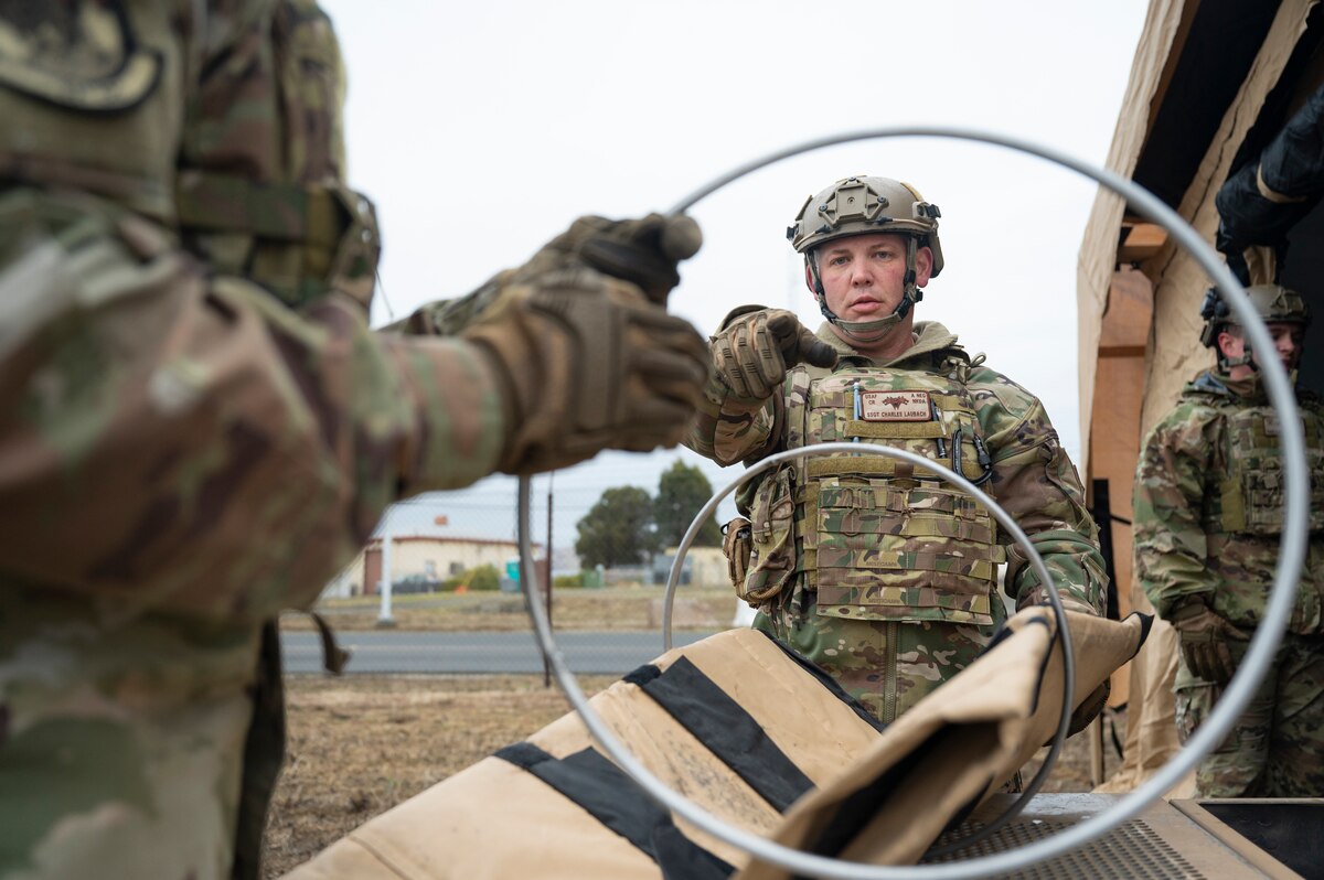 U.S. Air Force Staff Sgt. Charles Laubach, an 821st Contingency Response F-15 maintainer, sets up an air duct during a part task trainer at the Global Readiness Deployment Center on Travis Air Force Base, California, Nov. 21, 2024.